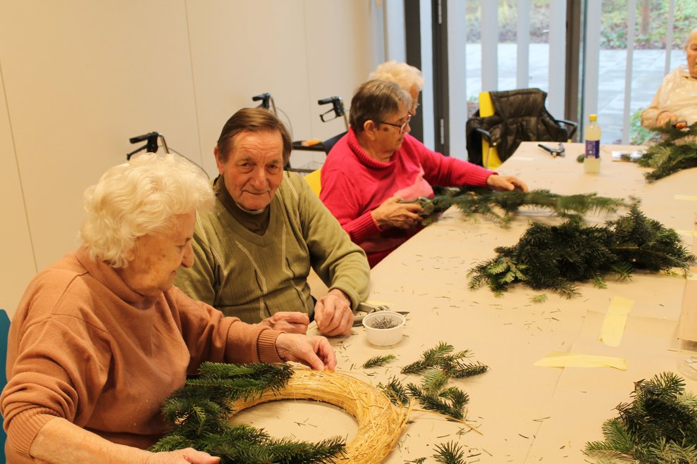 Vier Personen beim Adventkranzbinden
