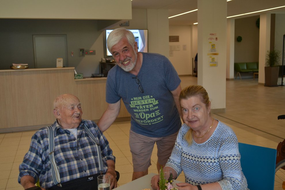 3 Personen lächeln in die Kamera