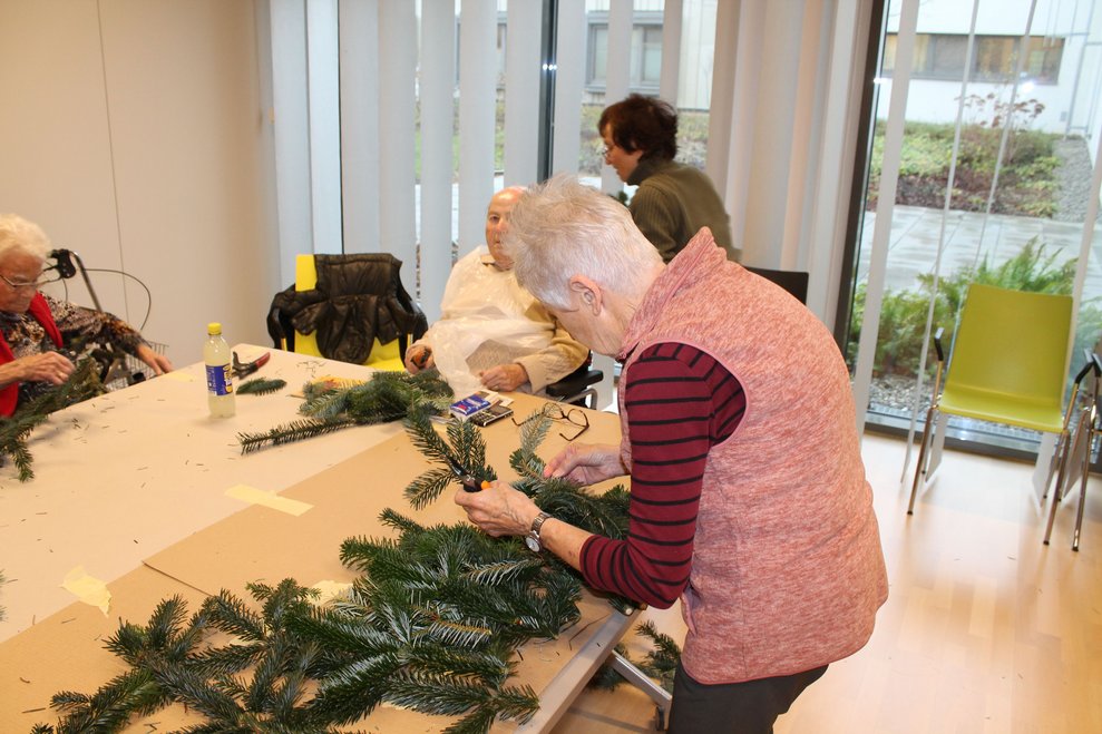 Frau beim Adventkranzbinden